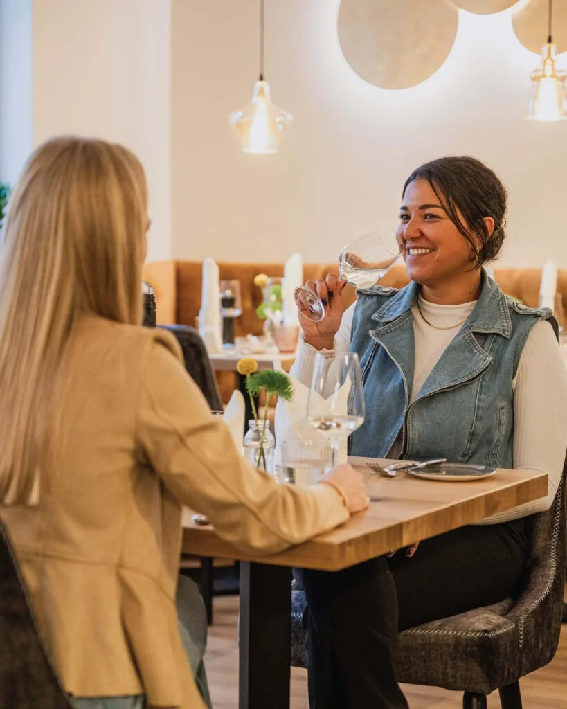Restaurant-Das-Muehlentor-zwei-Freundinnen-geniessen-einen-gemeinsamen-Abend-mit-Essen-und-Wein